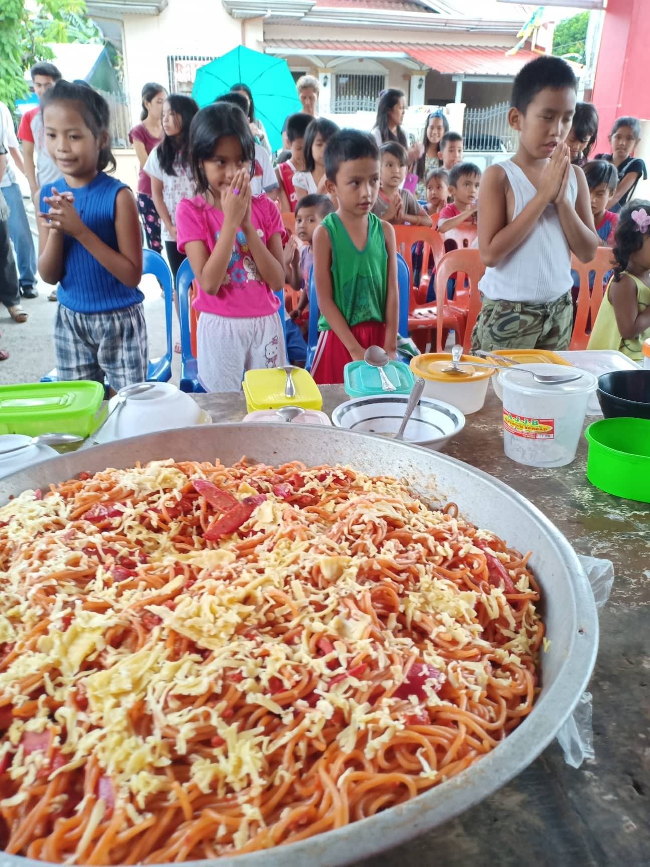Children praying before a large meal